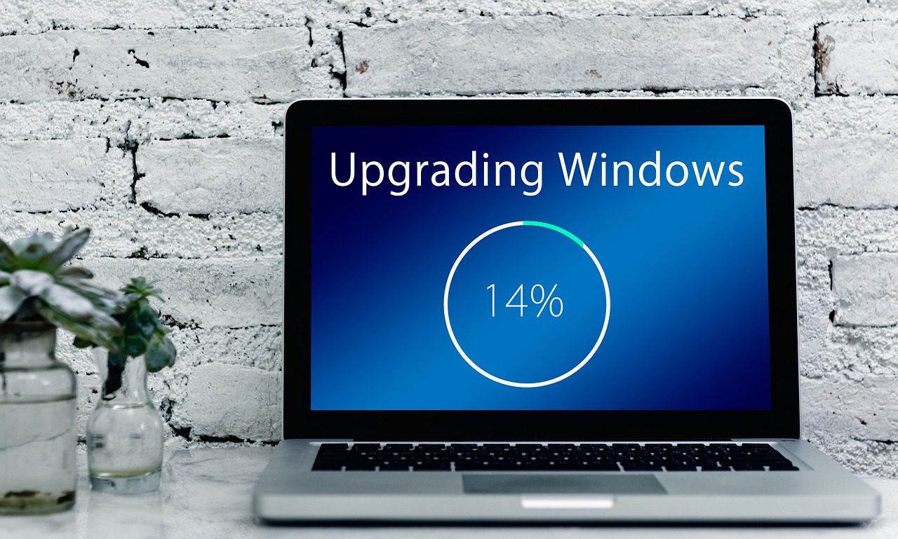The laptop screen shows "Upgrading Windows," representing an OS upgrade.
